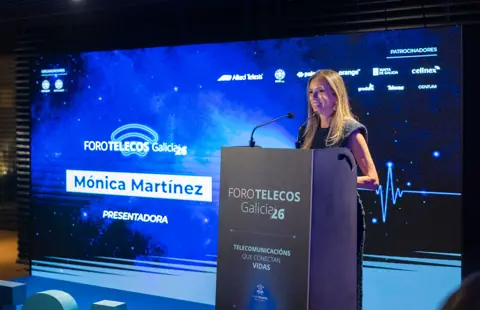 Unha presentadora no atril ante a pantalla do foro